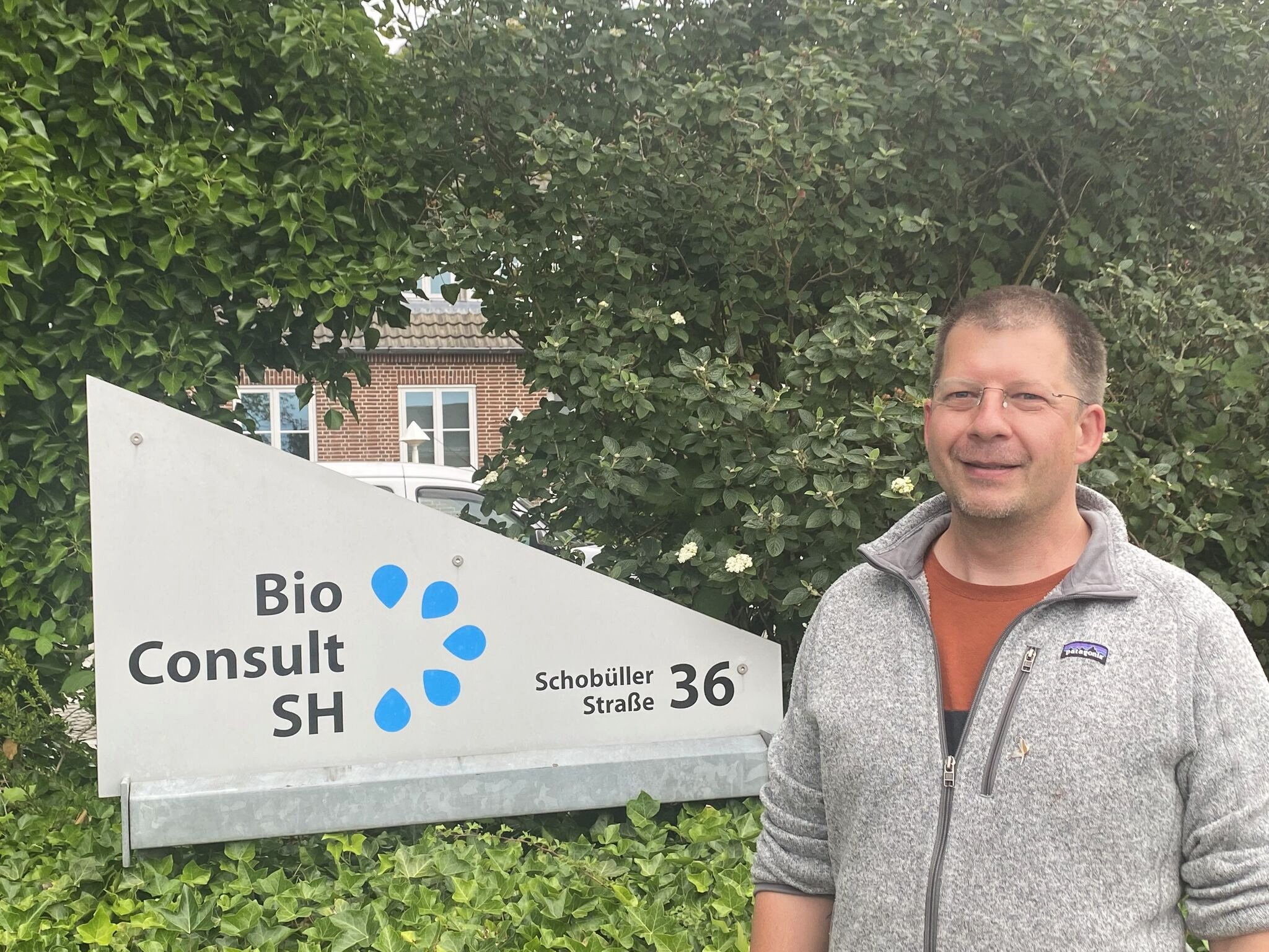 Dr. Thilo Liesenjohann stands in front of the company sign of BioConsult SH.