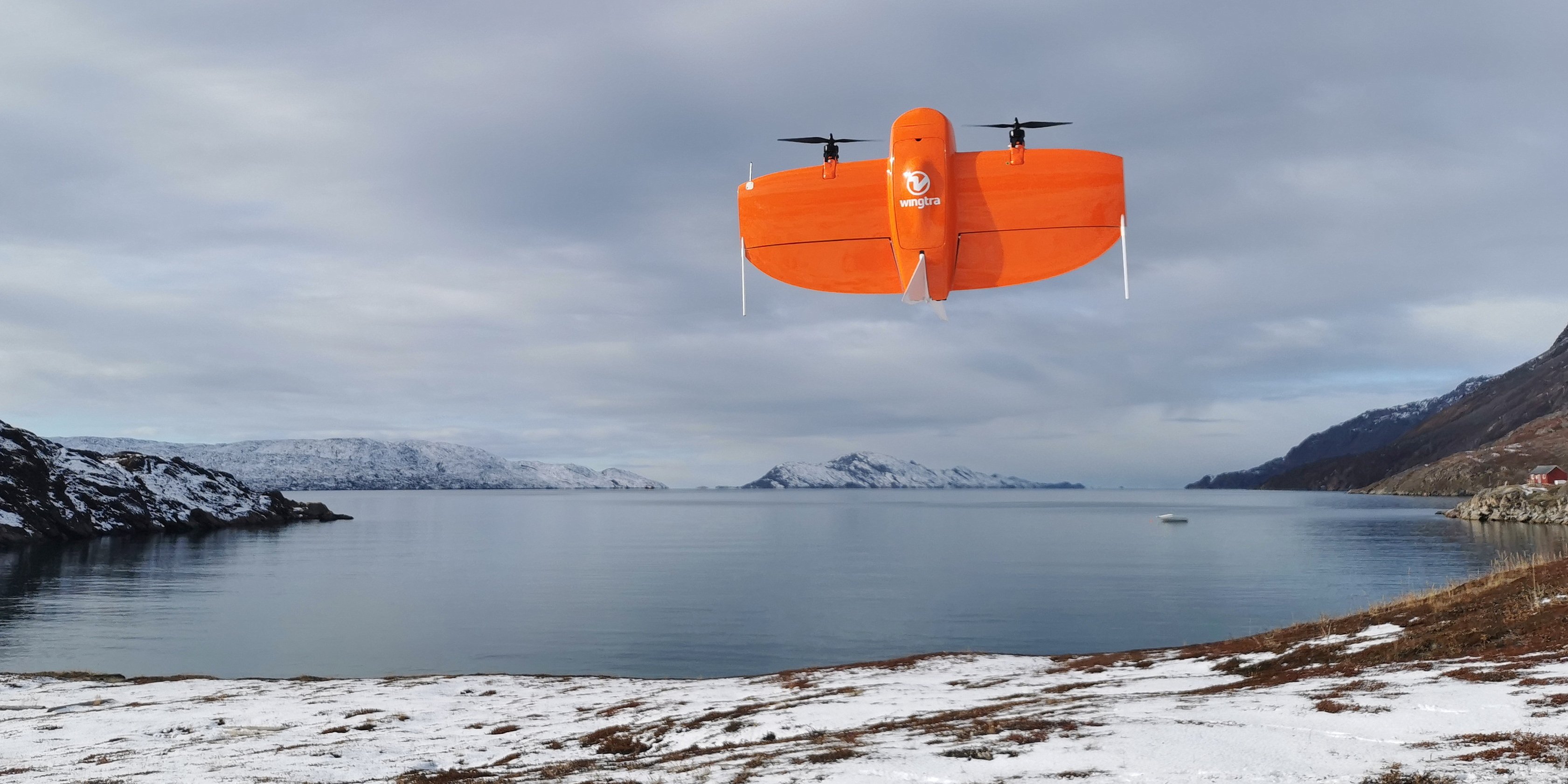 A red drone takes off from a bay in the Arctic.
