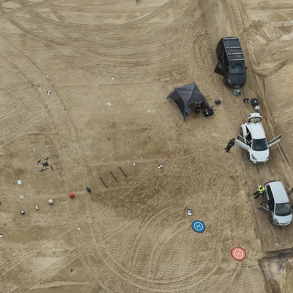 Luftaufnahme einer Multikopterdrohne über dem Testgelände. Auf dem Boden sind unterschiedliche Arten von Strandmüll ausgebracht. 
