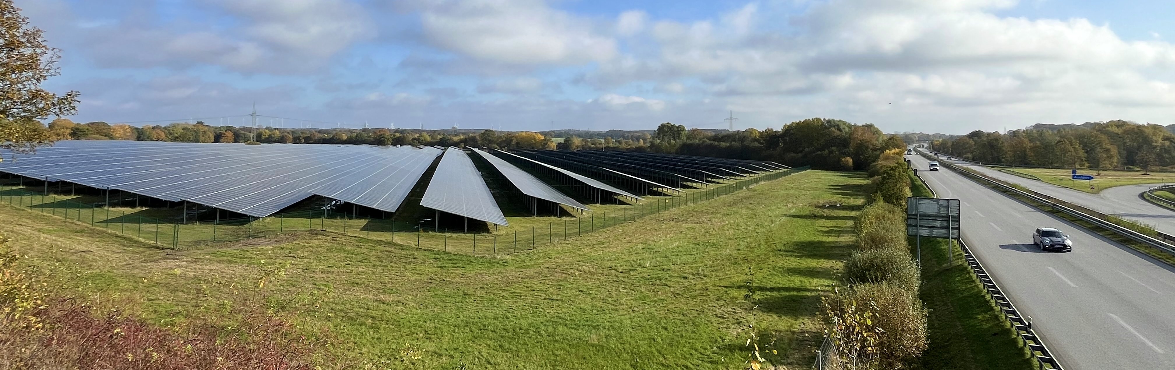 Photo of a solar park next to a motorway.